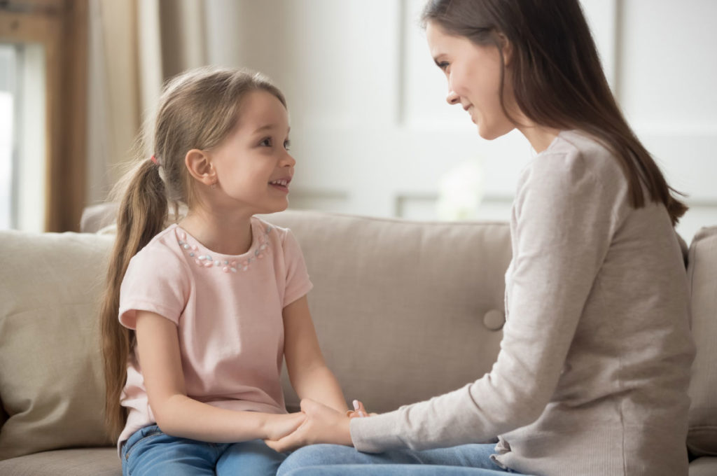 mother and daughter talking on couch